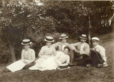 4 kvinnor och 2 män sittande i naturen
Nyckelord: Dragspel Dräkt Hatt