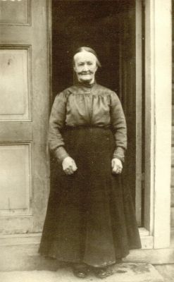 Kvinna stående i dörröppning
Lovisa Nilsson f. Karlsdotter
Nyckelord: Dräkt