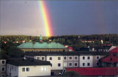 Regnbåge över stadsbebyggelse
