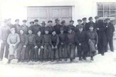 En grupp män framför en verkstadslokal
