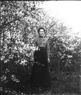 Kvinna stående i trädgård
Nyckelord: Dräkt