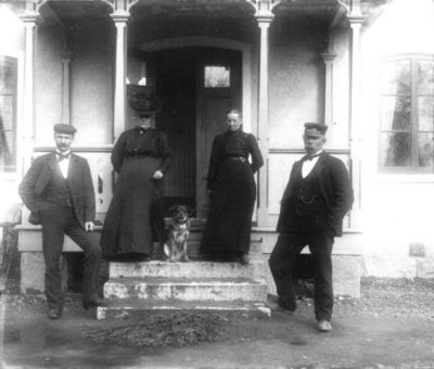 2 män 2 kvinnor och en hund framför byggnad
Nyckelord: Hund Dräkt Snickarglädje