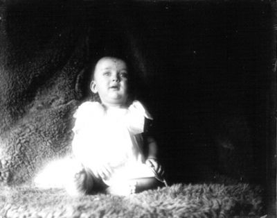 Litet barn sittande på fäll
Nyckelord: Fäll