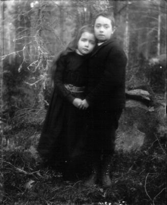 Pojke och flicka stående i skogen
