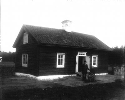 Man kvinna och hund framför byggnad
Nyckelord: Hund