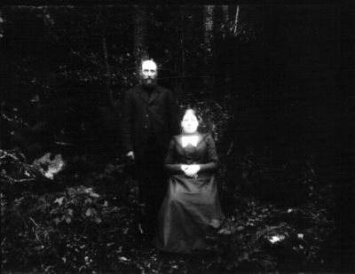 Stående man och sittande kvinna i naturen
