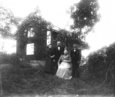 2 män och 2 kvinnor framför byggnad
