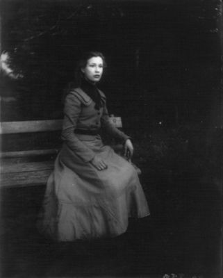 Kvinna sittande på parkbänk
