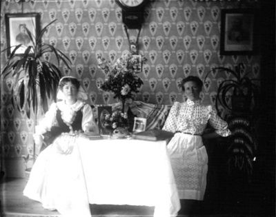 2 kvinnor sittande i rum
Nyckelord: Tapet Foto Dräkt