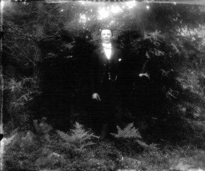 Högtidsklädd man stående i skogen
Nyckelord: Klockkedja Dräkt