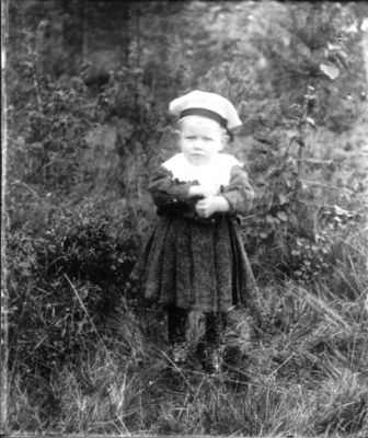 Flicka stående i gräset
Nyckelord: Dräkt