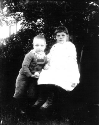 Pojke och flicka i trädgård
Nyckelord: Dräkt