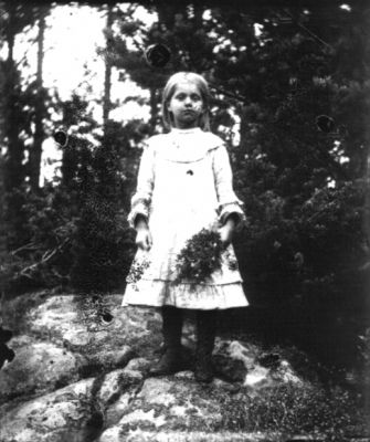 Flicka med blombukett stående i skogen
Nyckelord: Dräkt