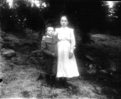 Pojke och flicka stående i naturen
Nyckelord: Dräkt