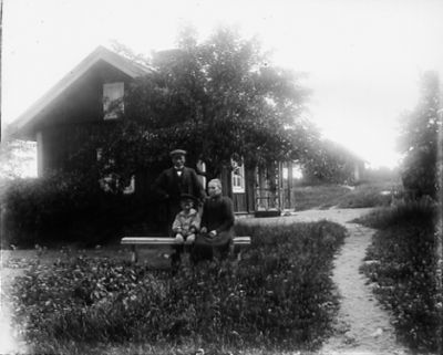 Man kvinna och pojke framför byggnad
