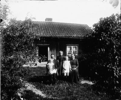 Man kvinna och 3 barn farmför byggnad
