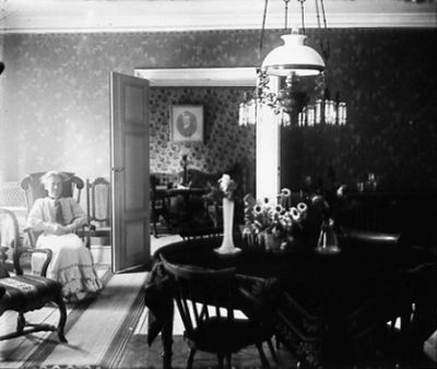 Kvinna sittande i rum
Nyckelord: Tapet Fotogenlampa Gungstol Porträtt