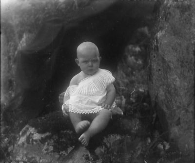 Baby sittande i grottöppning
Nyckelord: Dräkt
