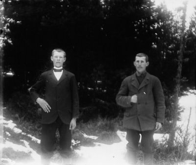2 män stående i skogen
