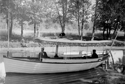 2 män sittande i båt i vattendrag
Nyckelord: Ångbåt