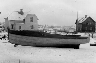 Båt på tomt framför 2 byggnader
Nyckelord: Båt Byggnad