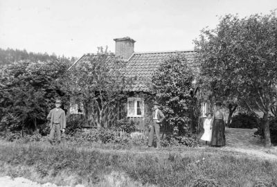 Män och kvinnor vid byggnad på landsbygden
