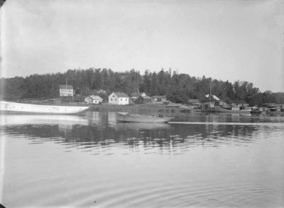 Båt på vattendrag med byggnader i bakgrunden
