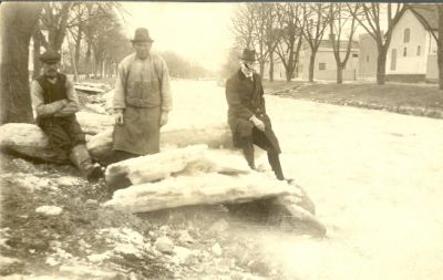 3 män stående vid isflak intill vattendrag
