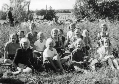 Flickor sittande i gräset
