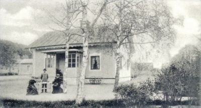 Man och 2 kvinnor framför villa
