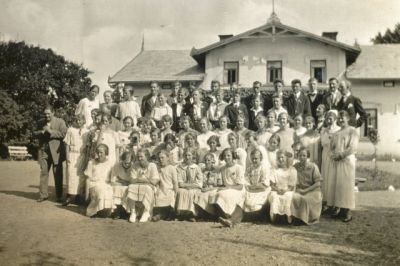 En grupp ungdomar med ledare framför byggnad
