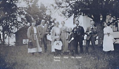 Män kvinnor och barn framför byggnad
