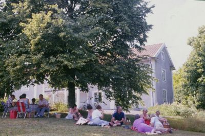 Kaffepaus på gräsmatta framför byggnad
