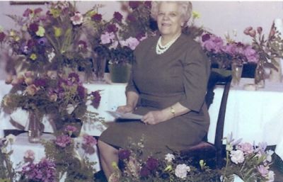 Kvinna sittande bland blommor
