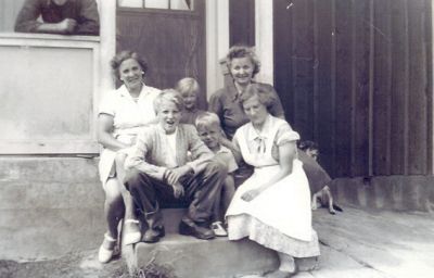 3 kvinnor och 3 barn på verandatrappa
