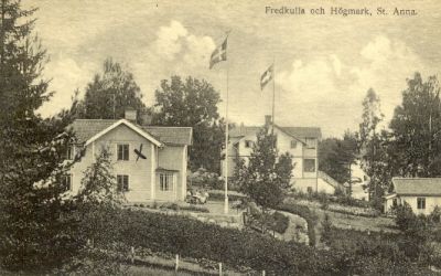 Två byggnader invid sjö
