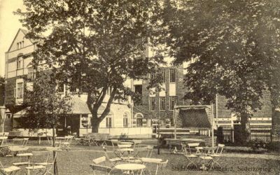 Park framför stor tegelbyggnad
