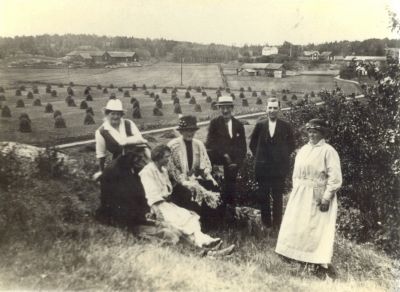 7 personer på kulle med lantgårdar i bakgrunden
