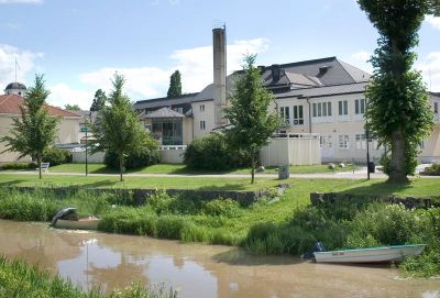 Stor byggnad intill vattendrag
