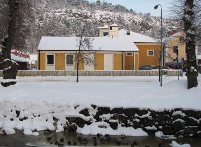 Gul byggnad invid vattendrag
