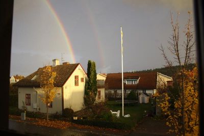 Dubbla regnbågar över stadsbebyggelse
