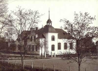 Vitputsad byggnad med plåttak

