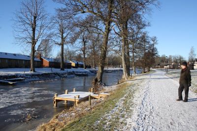 Vintervy mot byggnader intill vattendrag
