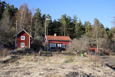 Rött torp i skogsbryn
